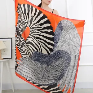 Elegant large square scarf with striking zebra and wing print on vibrant orange background.