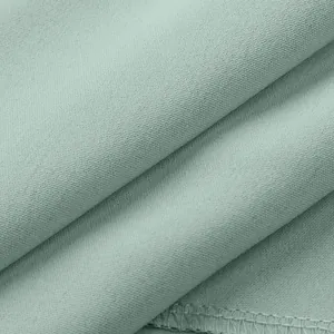 Detailed view of light green fabric texture and clean edge stitching for womens wear.