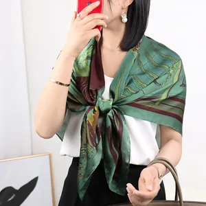 Close-up detail of luxurious green printed silk square scarf worn by model showcasing drape style