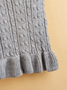 Close-up view of soft grey cable-knit pet sweater detail, showcasing fine texture and cute hem.