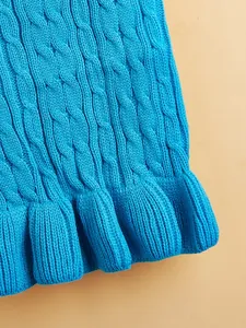 Close-up detail of bright blue cable knit pet sweater with ruffled hem, soft texture for small dogs.