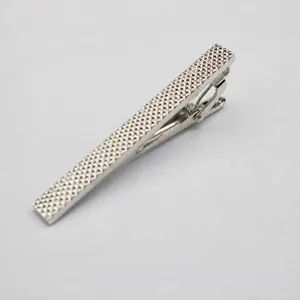 Silver metal tie clip for men, textured geometric pattern, elegant business accessory detail.