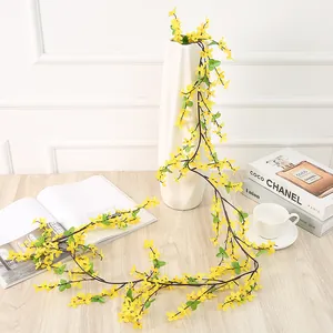 Détail de vigne de fleurs artificielles en soie, guirlande jaune vive pour la décoration.