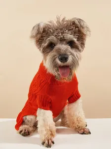 Close-up detail of the soft orange cable knit pet sweater worn by a cute puppy in studio.