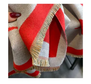 Close-up detail of the cozy red and grey color block winter scarf featuring delicate fringes.