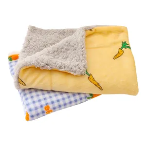 Cozy pet sleeping mat with cute carrot pattern and soft sherpa lining for winter warmth.