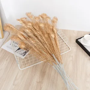 Artificial gold peacock feather branches for home decor, floral arrangement, and vase display.