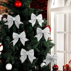 Zilveren glitter kerststrikken hangend aan de boom, stralende feestelijke decoratie ornamenten.