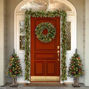 Luxurious Christmas pine needle wreath and garland set with warm LED lights on a front door