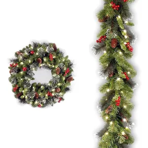 Frosted Christmas wreath and garland set with warm LED lights, red berries, and pine cones