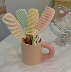 Joli set de peignes pastel avec tasse de rangement en céramique et poignée en plastique.