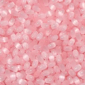Perles de riz en verre rose œil de chat gros plan détail, perles brillantes pour bijoux DIY.