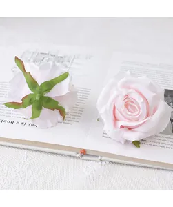 Close-up detail of artificial pink rose flower head showing petal and green sepal.