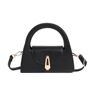 Black structured handbag detail, elegant arch handle, chic gold tone clasp and shoulder strap.