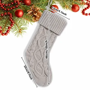 Detail view showing dimensions of a gray knitted Christmas stocking in cm and inch.