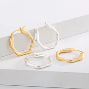 Primo piano di orecchini a cerchio geometrici in acciaio inox nei colori oro e argento