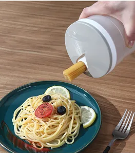 Macro view of a white plastic noodle storage jar dispensing spaghetti onto plate