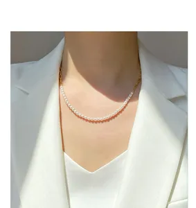 Elegante Süßwasserperlenkette mit Goldkettendetail an einem Modell in weißem Blazer.