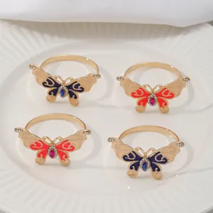Close-up of elegant butterfly napkin rings with gold-tone metal, enamel and rhinestones.