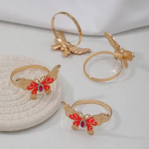 Detailed shot of gold butterfly napkin ring with red enamel and rhinestones for table decor.