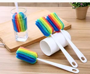 Detalle de cepillo colorido para tazas con mango blanco para una fácil limpieza de botellas.