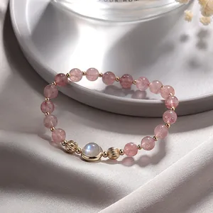 Detailed macro shot of a natural strawberry quartz bracelet with blue-flash moonstone centerpiece