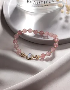 Macro view of natural strawberry quartz bracelet with blue fire moonstone and gold accents.