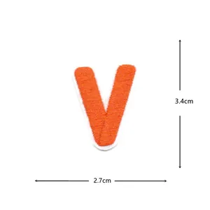 Detailed view of the orange embroidered letter V patch, clothing accessory decoration measuring 3.4x2.7cm.