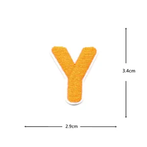 Close-up detail of a bright orange embroidered letter Y fabric patch, showing fine stitching.