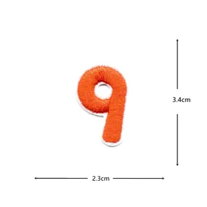Orange number 9 embroidered patch detail closeup, fabric applique badge for DIY clothing decoration.