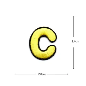 Yellow embroidered letter C patch detail, black border clothing accessory 2.8x3.4cm.