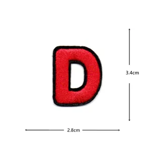 Red and black embroidered letter D patch close-up, clothing accessory DIY repair detail.