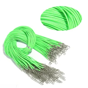 Detail view of neon green wax cord necklace strings featuring lobster clasps and extension chains.