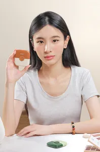 Detailed view of portable 2-in-1 hair trimmer held by model for trimming bangs