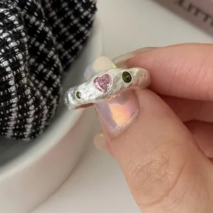 Detaillierte Nahaufnahme eines unregelmäßigen Silberrings mit einem rosa Herzstein