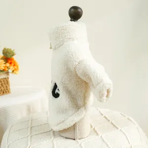 Detailed view of a soft white pet fleece winter coat with cozy collar and cute letter detail.