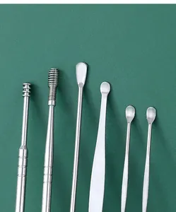 Close-up detail of stainless steel ear pick tool set, multi-functional earwax cleaning spoons.