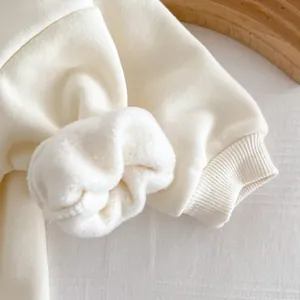 Gros plan sur la manchette sweat bebe en polaire blanche, detail vetement hiver.