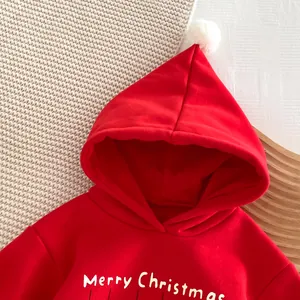 Sweat-shirt de Noël pour bébé rouge à capuche avec pompon et motif festif en polaire.