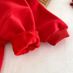 Détail de manchette en tissu polaire rouge barboteuse bébé hiver chaud doux gros plan
