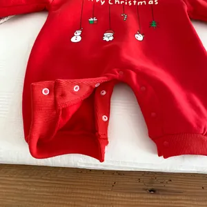 Détail de combinaison bébé Noël en polaire douce, couleur rouge et boutons pression pratiques.