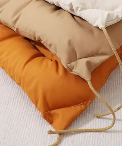 Close up detail of thick soft pet cushion pad with convenient fixing ties in warm cozy colors.