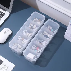 Scatola organizer trasparente per cavi da scrivania in plastica con vari comparti.