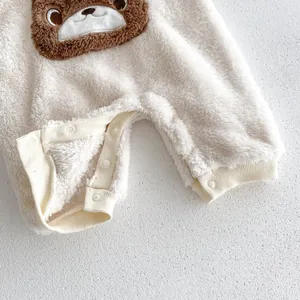 Close-up of fluffy baby fleece romper with cute bear appliqué and secure snap buttons.