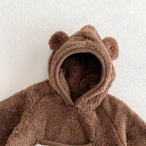 Brown baby fleece romper with cute bear ears, close-up detail shot for autumn and winter.