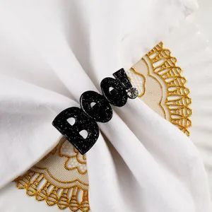 Halloween black glitter BOO letter napkin ring detail shot for elegant holiday table decor.