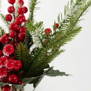 Branches de pin de Noël artificielles avec baies rouges givrées pour décoration de fête.
