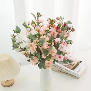 Artificial wild rose flower bouquet in white ceramic vase for home living room decor.