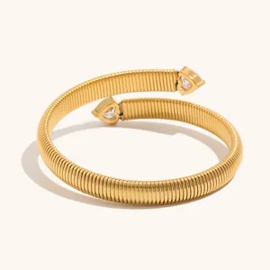 Detail of gold-plated striped heart zircon bracelet with coiled stainless steel band