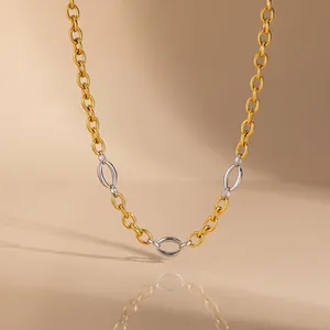 Detailed macro view of a mixed-metal stainless steel chain necklace with gold and silver links